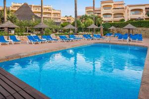 米哈斯科斯塔Wyndham Grand Costa del Sol的一个带躺椅的游泳池和一个位于酒店后面的酒店