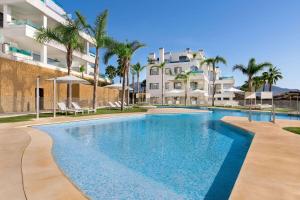 米哈斯科斯塔Wyndham Grand Costa del Sol的棕榈树环绕的建筑物前的游泳池 更多37张照片