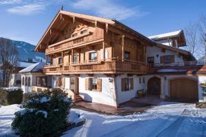 a large wooden house with a balcony in the snow at Haus Sonnenschein in Hart im Zillertal