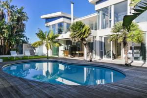 een zwembad voor een huis met palmbomen bij GND Properties Luxury Holiday Home in Summerstrand