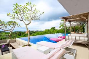 une terrasse avec mobilier blanc et une piscine dans l'établissement Villa Aventus Uluwatu, à Uluwatu