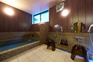 a large bathroom with a tub and a sink at Uminone in Toyooka