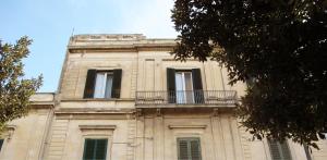 un edificio con balcone sopra di Volver B&B a Lecce