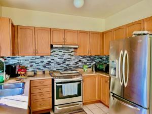 a kitchen with wooden cabinets and a stainless steel refrigerator at Extended Stays Home in Markham