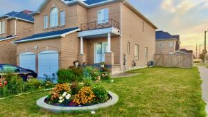 a house with a flower garden in front of it at Long Stay Home in Markham