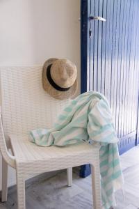 a hat sitting on a wicker chair with a blanket at Drakos Twins in Mylopotas
