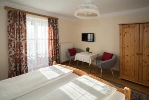 um quarto com uma cama, uma mesa e uma janela em Haus Kendlinger em Sankt Gilgen