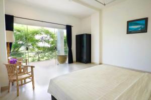 une chambre avec un lit et une chaise et un balcon dans l'établissement Villa Aventus Uluwatu, à Uluwatu