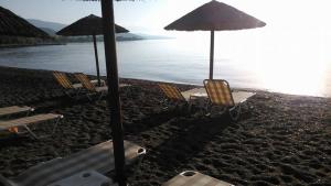 a group of chairs and umbrellas on a beach at Tokalis Boutique Hotel & Spa in Nea Anchialos