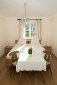 a room with two beds and a table and a window at Haus Kendlinger in Sankt Gilgen