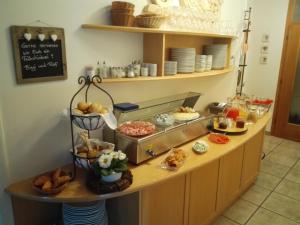 ein Frühstücksbuffet mit Brot und Speisen auf der Theke in der Unterkunft Pension Sonnalp in St. Ulrich in Gröden