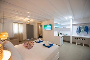 een grote witte kamer met een bed en een bureau bij Villa Leda Mykonos in Mykonos-stad +57 foto's