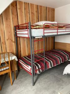 two bunk beds in a room with a wooden wall at B9 villa MASSIAS in La Bourboule