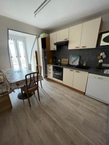 a kitchen with a table and a dining room at B9 villa MASSIAS in La Bourboule +4 photos
