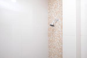 a shower with a shower head in a bathroom at Urbanview Hotel Grand Surya Yogyakarta in Timuran