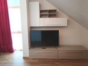 a tv sitting on a dresser in a living room at Appartamento 2 Residenza RODODENDRO in Campitello
