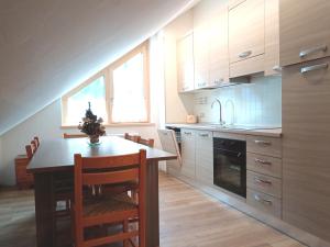 a kitchen with a table and some chairs in a room at Appartamento 2 Residenza RODODENDRO in Campitello