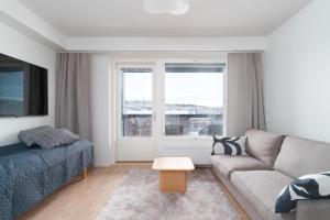 a living room with a couch and a window at Rahulihomes Lutakko in Jyväskylä
