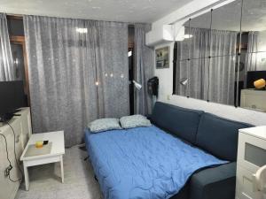a small bedroom with a blue bed and a television at Puerto Rico Apartment Terrace Gran Canaria in Puerto Rico de Gran Canaria +24 photos