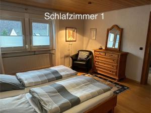 a bedroom with two beds and a chair and a dresser at Ferienwohnung Anke Kaufmann in Miltenberg
