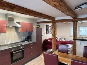 een keuken met rode kasten en een woonkamer bij Am Graben 2 in Hasselfelde
