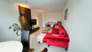 a living room with a red couch and a tv at RelaxDays-Apartments 2 GARTEN und POOL- Mitbenutzung, kostenloser Parkplatz, kontaktloser CheckIn, WiFi mit SmartTV in Gütersloh