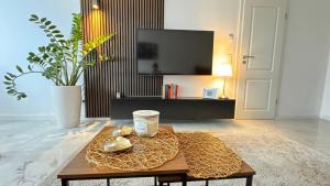 a living room with a coffee table and a tv at RelaxDays-Apartments 2 GARTEN und POOL- Mitbenutzung, kostenloser Parkplatz, kontaktloser CheckIn, WiFi mit SmartTV in Gütersloh +7 photos