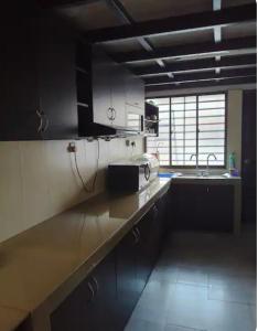 eine Küche mit einer Theke mit einer Mikrowelle und einer Spüle in der Unterkunft LSH Homestay in Seremban + 28 Fotos