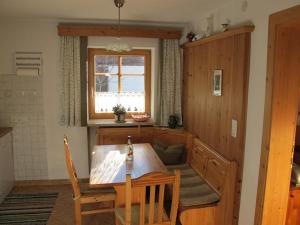 a kitchen with a wooden table and a window at Hauspircher in Reith bei Seefeld