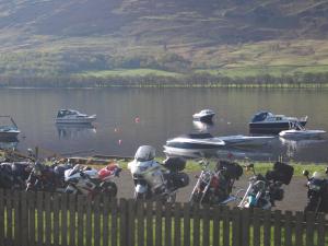 a group of motorcycles parked next to a body of water at The Clachan Hotel, Lochearnhead in Lochearnhead