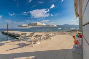 a group of chairs and umbrellas on a beach at Grand Hotel View in Postira