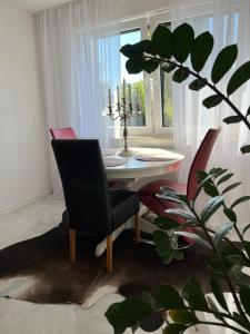 a dining room with a table and chairs and a plant at RelaxDays-Apartments 2 GARTEN und POOL- Mitbenutzung, kostenloser Parkplatz, kontaktloser CheckIn, WiFi mit SmartTV in Gütersloh