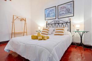 a bedroom with a large white bed with yellow pillows at Ca La Maria in Santes Creus