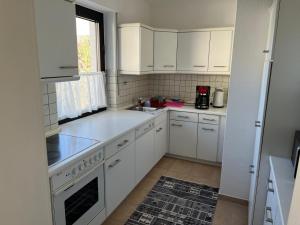 a white kitchen with white cabinets and a window at WohlfühlQuartier Schwedenstein in Bad Oeynhausen