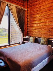 a bedroom with a large bed with a window at גן הדובדבנים in Odem