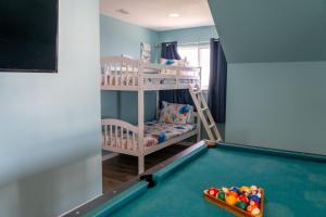 a kids room with a pool table and bunk bed at Strand Castle - GULF FRONT! An ideal layout with game room, small private pool, and roof top crow's nest! home in Dauphin Island