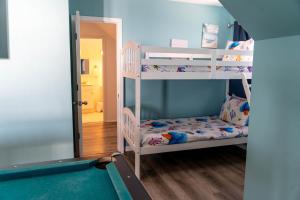 a bedroom with bunk beds and a pool table at Strand Castle - GULF FRONT! An ideal layout with game room, small private pool, and roof top crow's nest! home in Dauphin Island