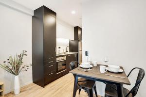 a dining room with a table and chairs in a kitchen at Stunning Studio Close to SkyTower - Pool Gym Sauna in Auckland +6 photos