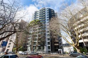 a tall building with cars parked in front of it at Stunning Studio Close to SkyTower - Pool Gym Sauna in Auckland