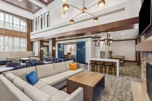アルバニーにあるStaybridge Suites Albany Wolf Rd-Colonie Center by IHGのソファとテーブルのあるリビングルーム