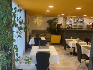 a restaurant with tables and chairs in a room at LOGIS Hôtel La Chaumière in Marseillan