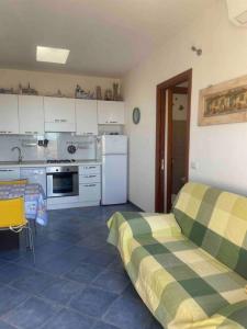 una cocina con armarios blancos y una cama en una habitación en Casa Cynthia, en Codaruina