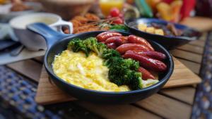a bowl of food with broccoli and tomatoes on a table at SARASA HOTEL Namba in Osaka