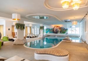 duży basen w pokoju z dużym obrazem w obiekcie Hotel Hochfilzer w mieście Ellmau