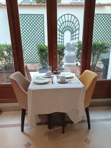 una mesa con 2 sillas y un mantel blanco en Hotel des Bains, en París