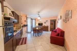 a kitchen with a red couch and a dining room at Casa Le Pleiadi in Montesilvano Marina