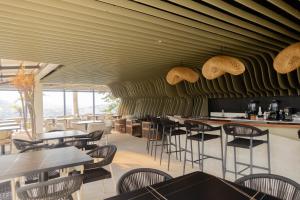 a restaurant with tables and chairs and a green wall at Hostel Honeycomb Cebu in Cebu City