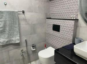 a bathroom with a white toilet and a sink at Royal Villa's DHA in Lahore