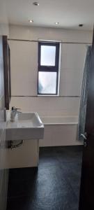 セントジュリアンズにあるVBH penthouse St Julian'sの洗面台と窓のあるバスルーム