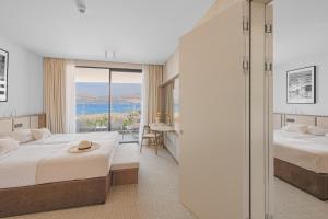 a hotel room with two beds and a balcony at Grand Hotel View in Postira